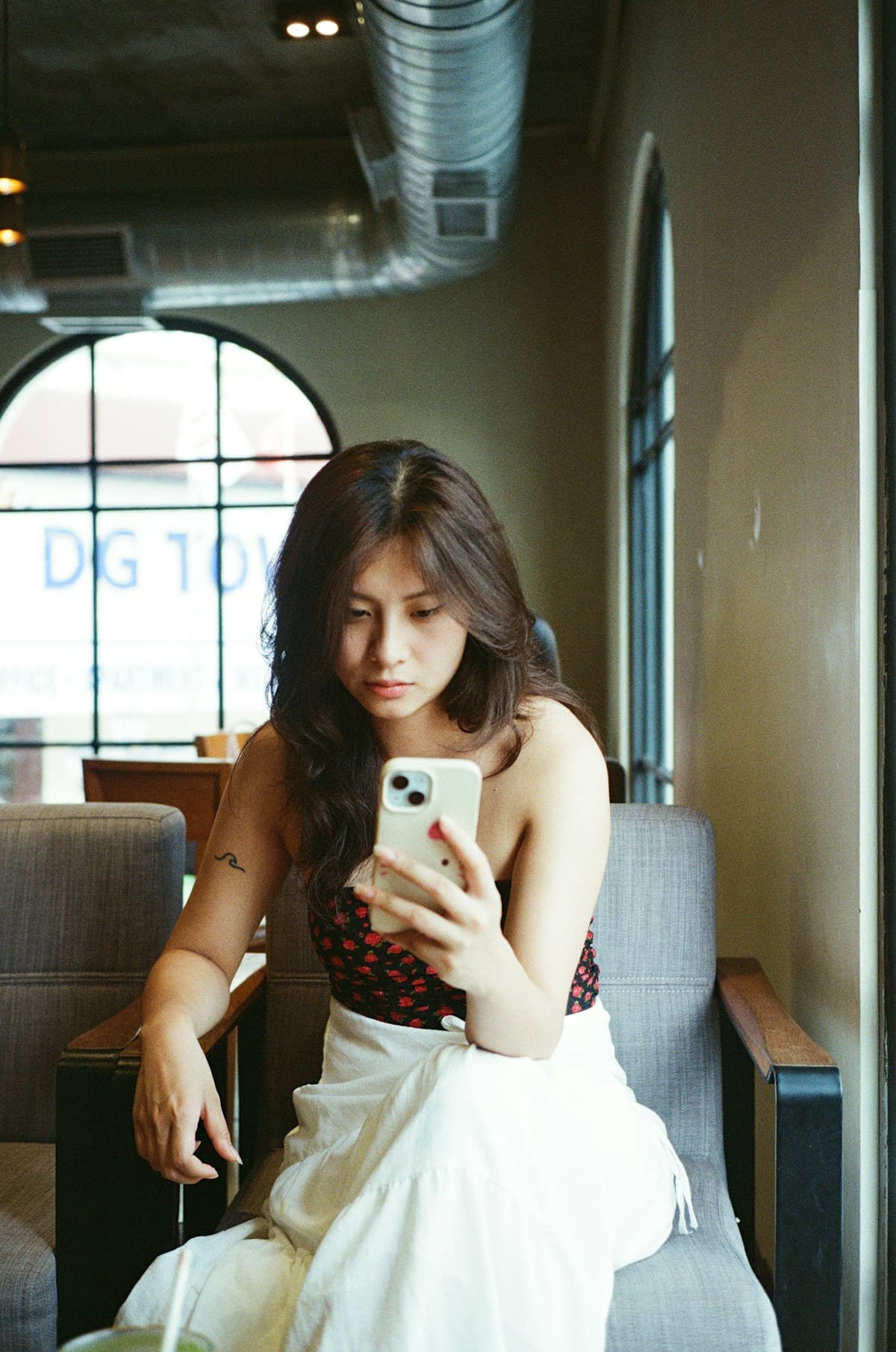 Woman checking her phone while sitting in a cafe